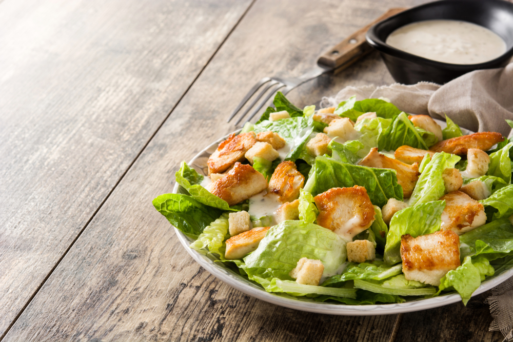 Caesar,Salad,With,Lettuce,chicken,And,Croutons,On,Wooden,Table.,Copyspace
