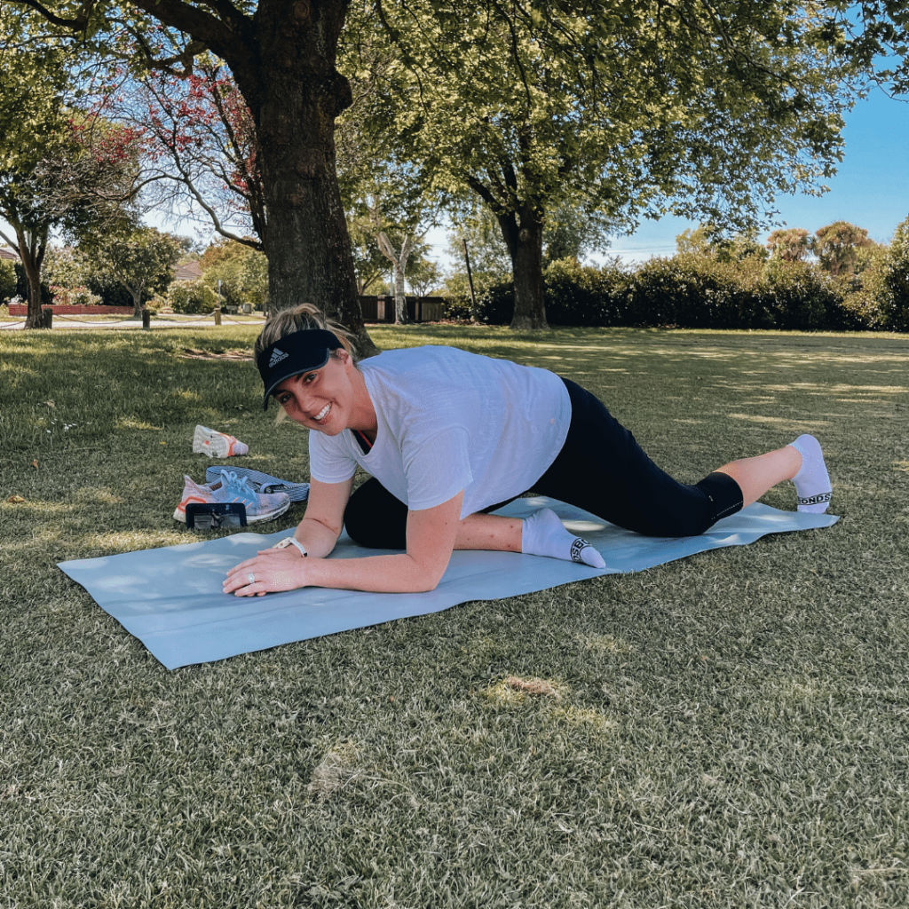 Hannah Romano doing pilates in the park on a yoga mat